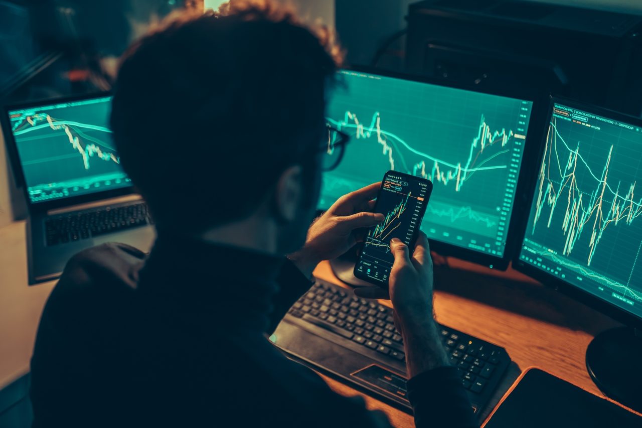 Trading Under the Stars Close-Up of a Man Analyzing Financial Data on a Smartphone Screen
